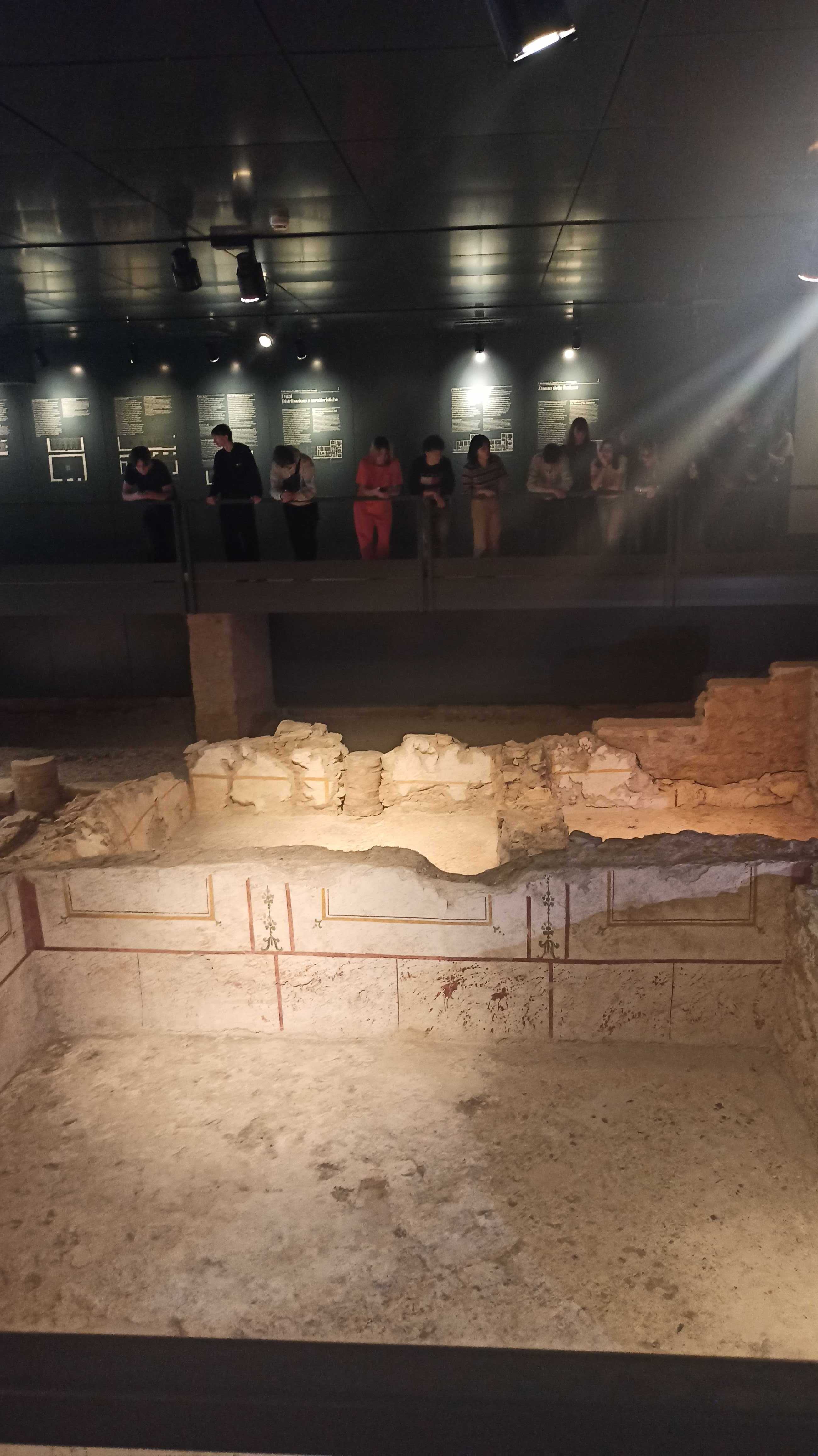 Students observing Roman ruins in an archaeology museum