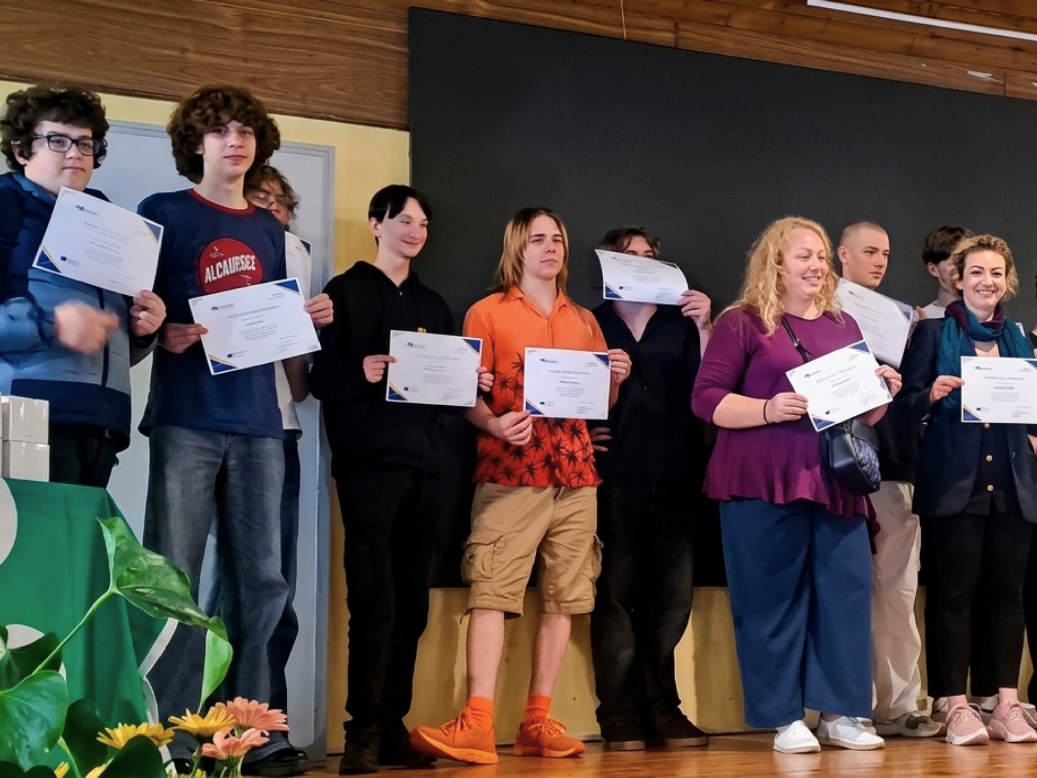 Students and teachers on stage holding Erasmus+ certificates