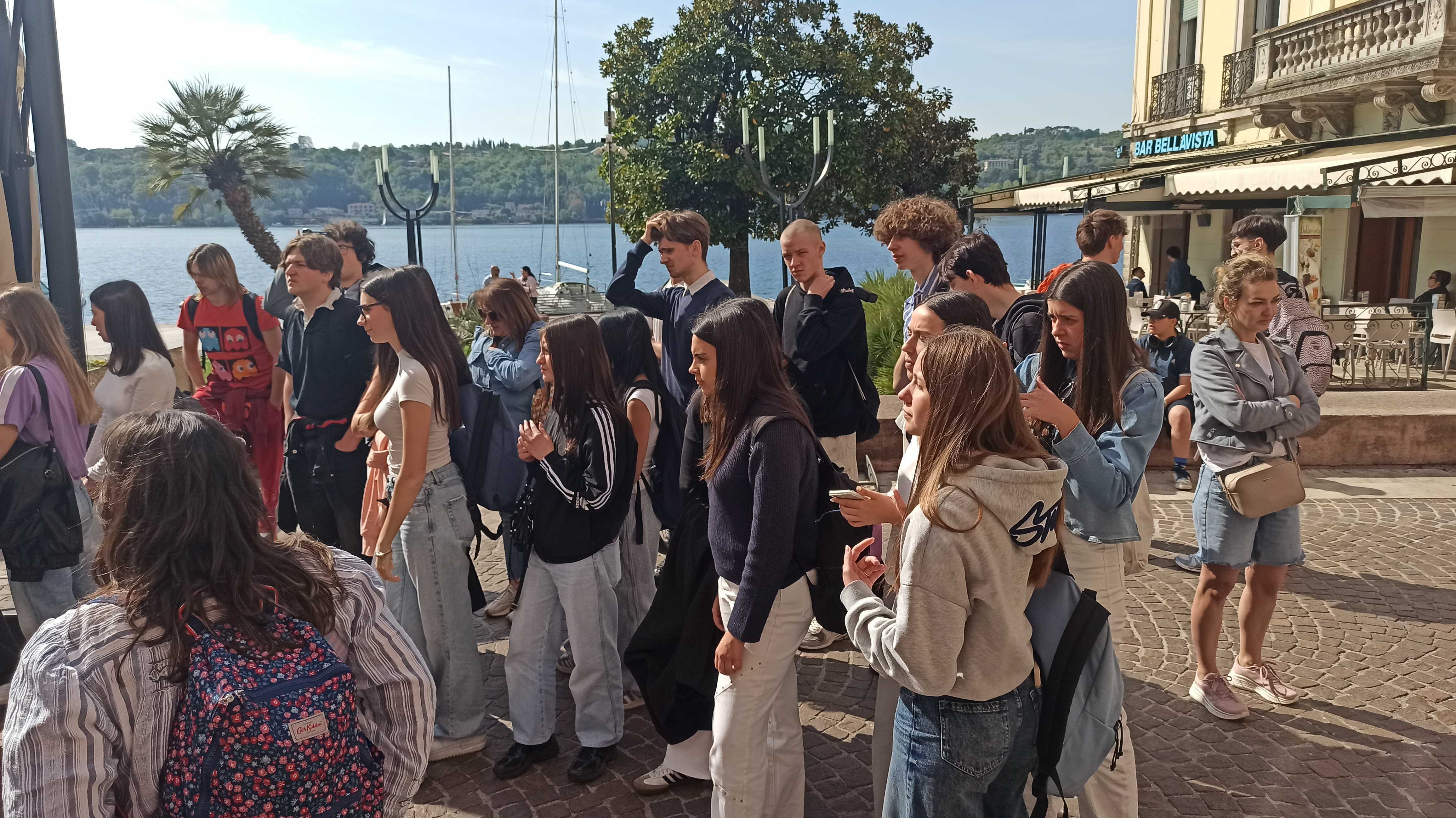 Students by a scenic Italian lakeside promenade