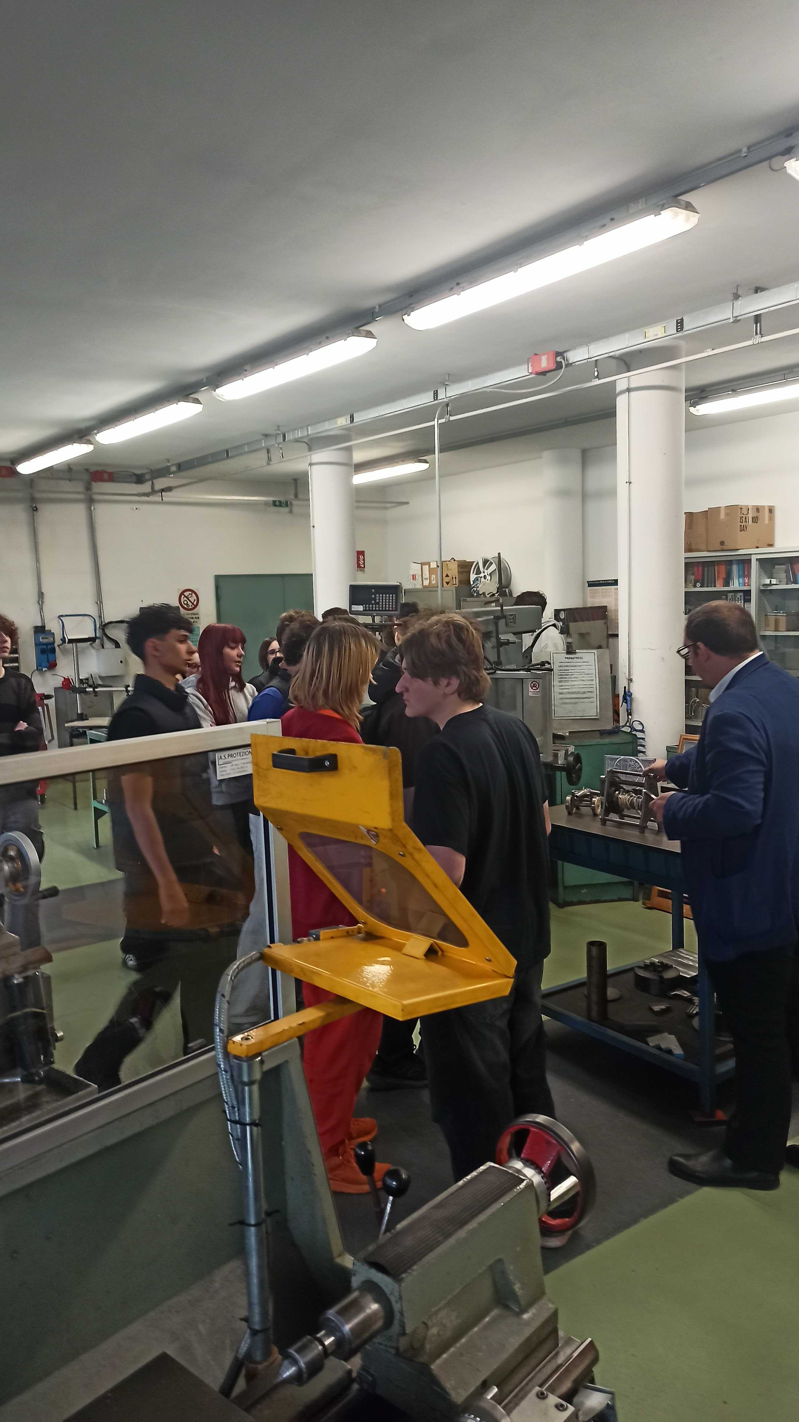 Students touring a machining workshop with a guide