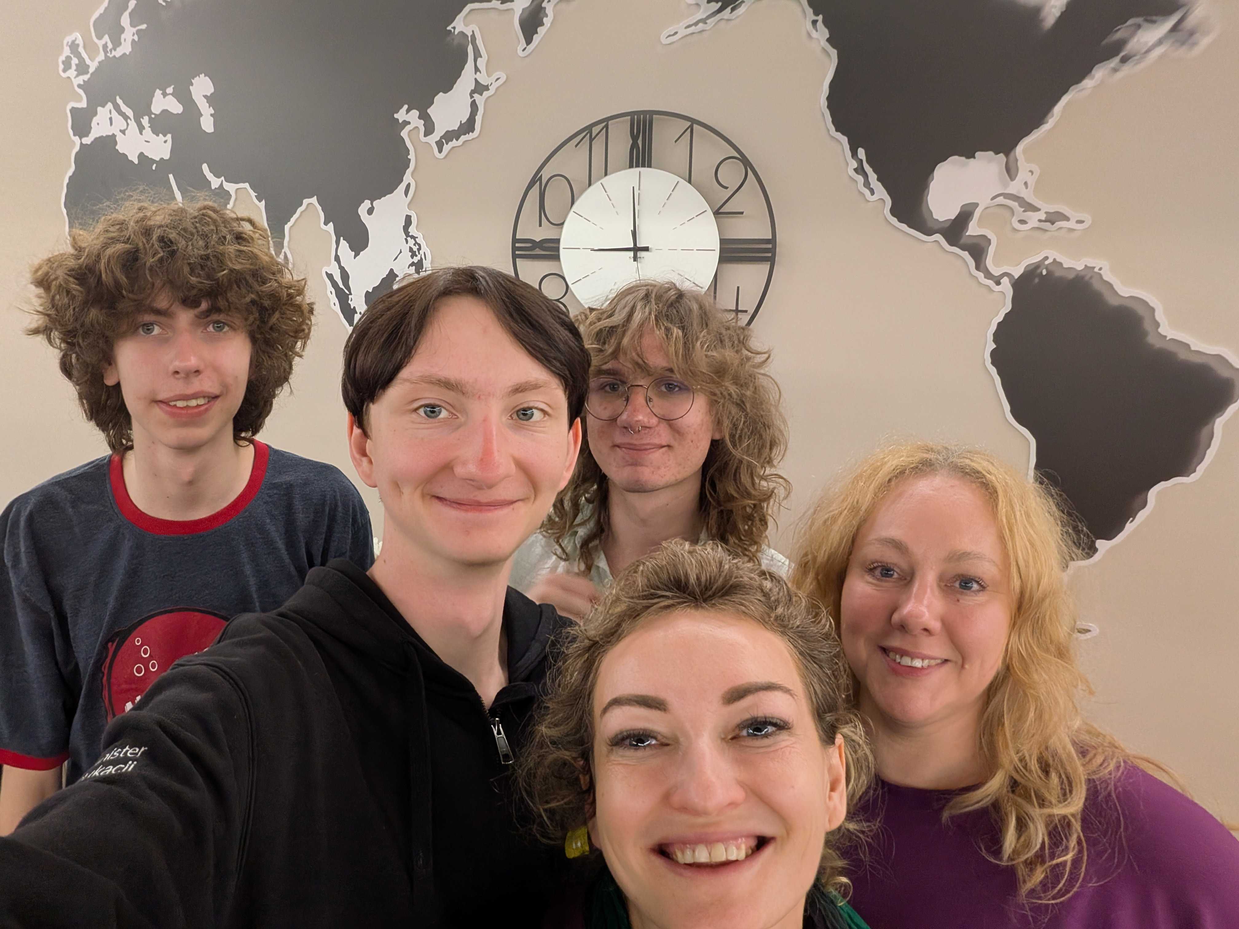 Group selfie in front of a world map wall